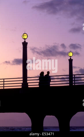 Couple walking on the Manhattan Beach Pier at twilight Stock Photo