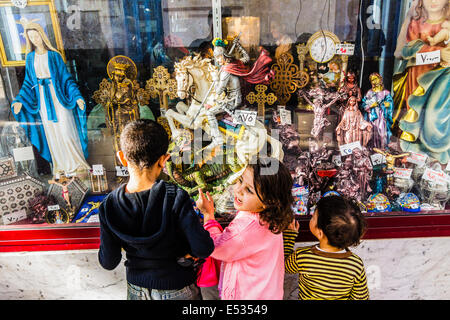 Coptic children staring at the window of a souvenirs shop at Deir al-Muharraq monastery. Egypt Stock Photo