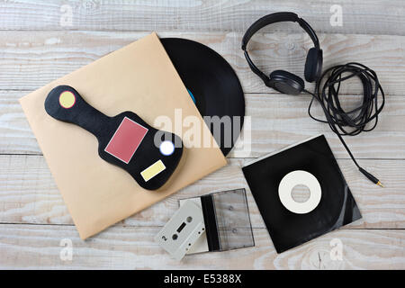 High angle shot of retro style music accessories. Items include: Vinyl LP, 45 rpm single, headphones, guitar case and a cassette Stock Photo