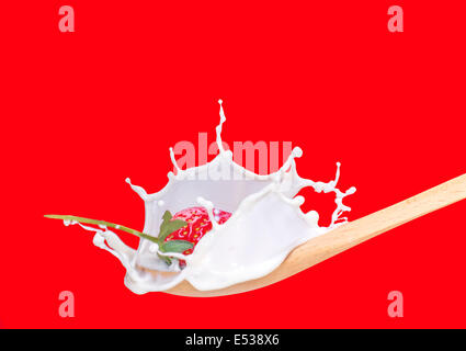 fresh strawberry splashing into spoon full of milk Stock Photo