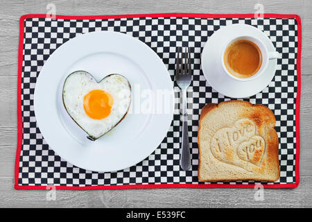Fried egg  in heart shape  and toast with love message.Breakfast for a loved one Stock Photo