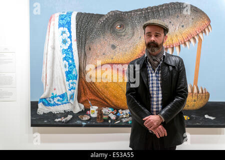 Sydney, Australia. 18th July, 2014. AUSTRALIA, Sydney. 18th July, 2014: 2014 Sulamn Prize winning artist Andrew Sullivan infront of his painting 'T-rex (tryant lizard king) The Archibald, Wynne and Sulman prize are major art prizes run by the Art Gallery of New South Wales with prizes of $75,000, $35,000 and $30,000 respectively. Credit:  MediaServicesAP/Alamy Live News Stock Photo