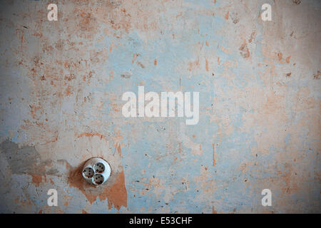 Old electric outlet on a rusty wall. Horizontal photo Stock Photo
