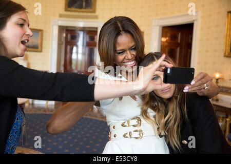 US First Lady Michelle Obama and Sarah Jessica Parker pose for a selfie in the Blue Room prior to the White House Talent Show hosted with the President's Committee on the Arts and the Humanities May 20, 2014 in Washington, DC. Kori Schulman, Director of Online Engagement, assists. Stock Photo