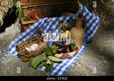 Wicker picnic basket and Wicker Wrapped Wine Jug in a rustic setting Stock Photo