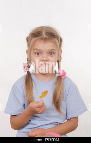 the five-year old girl enthusiastically eats candy Stock Photo