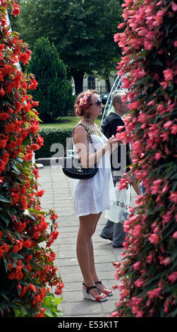 Lady in bloom standing between flowers in Esplanade Riga City Latvia Stock Photo