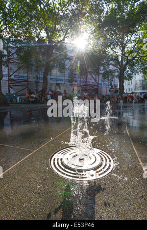 Leicester Square, London, UK. 19th July 2014. Londoners and tourists enjoy the fountains in Leicester Square around the statue of William Shakespeare. Credit:  Matthew Chattle/Alamy Live News Stock Photo