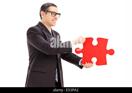 Businessman holding a piece of puzzle Stock Photo