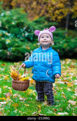 Laughing kid standing in an autumn park