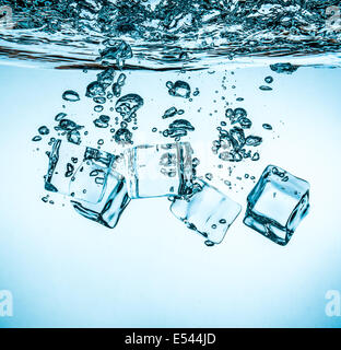 Ice cubes falling into the water sinking to the bottom. Abstract background. Stock Photo