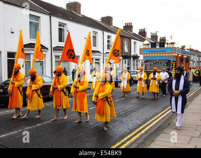 Middlesbrough, UK. 20th July, 2014. The annual Nagar Kirtan Parade celebrating Sikh culture in the North-east of England took place in Middlesbrough Cleveland UK today Sunday 20 July. The parade is led by five saffron robed men leading a float which carries the Guru Granth Sahib, the Sikh Holy Scripture.  Members of the procession are barefoot in deference to the scripture so displayed.  They are preceded by sweepers cleaning the road. Credit:  Peter Jordan NE/Alamy Live News Stock Photo