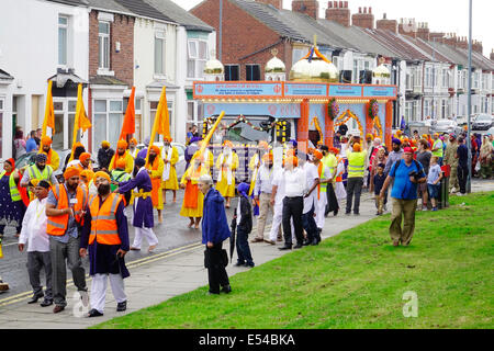 Middlesbrough, UK. 20th July, 2014. The annual Nagar Kirtan Parade celebrating Sikh culture in the North-east of England took place in Middlesbrough Cleveland UK today Sunday 20 July. The parade is led by five saffron robed men leading a float which carries the Guru Granth Sahib, the Sikh Holy Scripture.  Members of the procession are barefoot in deference to the scripture so displayed.  They are preceded by sweepers cleaning the road. Credit:  Peter Jordan NE/Alamy Live News Stock Photo