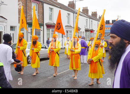 Middlesbrough, UK. 20th July, 2014. 'The annual Nagar Kirtan Parade celebrating Sikh culture in the North-east took place in Middlesbrough Cleveland UK today Sunday 20 July. The parade is led by five saffron robed men leading a float which carries the Guru Granth Sahib, the Sikh Holy Scripture.  Members of the procession are barefoot in deference to the scripture so displayed.  They are preceded by sweepers cleaning the road.    These five men leading the parade are the Panj Piare, the five loved by the Guru  ' Credit:  Peter Jordan NE/Alamy Live News Stock Photo