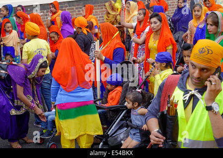 Middlesbrough, UK. 20th July, 2014. The annual Nagar Kirtan Parade celebrating Sikh culture in the North-east of England took place in Middlesbrough Cleveland UK today Sunday 20 July. The parade is led by five saffron robed men leading a float which carries the Guru Granth Sahib, the Sikh Holy Scripture.  Members of the procession are barefoot in deference to the scripture so displayed.  They are preceded by sweepers cleaning the road. This picture shows the Sikh families getting ready to follow the float at the back of the parade Credit:  Peter Jordan NE/Alamy Live News Stock Photo