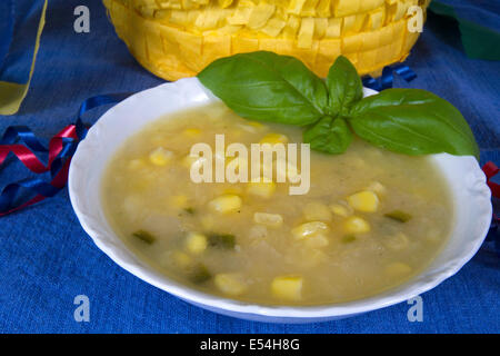 Bowl of Southwestern Potato and Corn Soup served with basil sprig with pinata Stock Photo