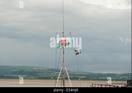welsh flag flying in aberdovey on a fishing boat with the estuary in the background Stock Photo