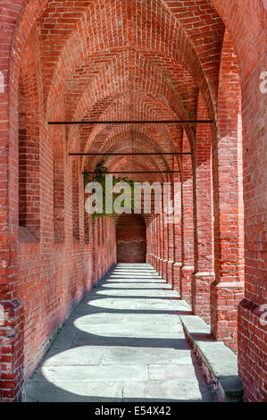 Old narrow red brick arcade in town of Pollenzo in Piedmont, Northern Italy. Stock Photo