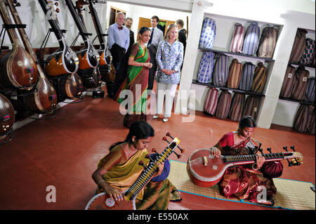 US Secretary of State Hillary Rodham Clinton watches two women practice playing the veena, a traditional Indian stringed instrument during a visit to Kalakshetra cultural academy July 20, 2011 in Chennai, India. Stock Photo