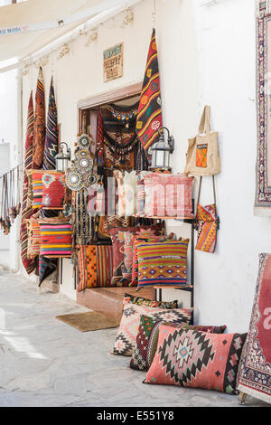 Shop in Kusadasi, Turkey, selling souvenirs displaying local cushions, rugs, carpets and fabrics on the roadside Stock Photo