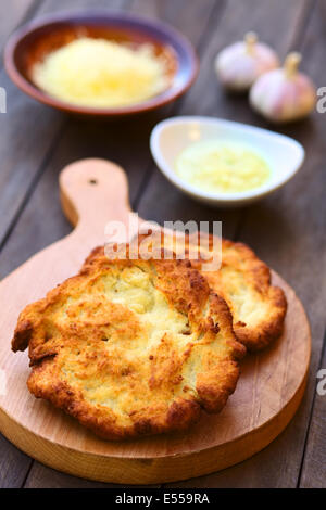 Freshly prepared traditional Hungarian deep fried flat bread called Langos made of a yeast dough Stock Photo
