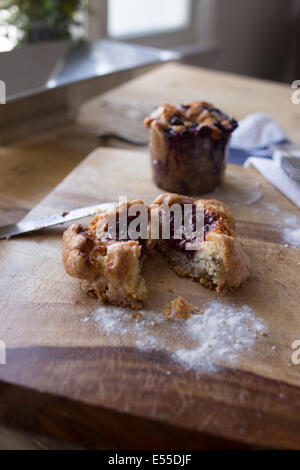 Strawberry tart and blueberry muffin on breakfast table with knife and napkin. Stock Photo