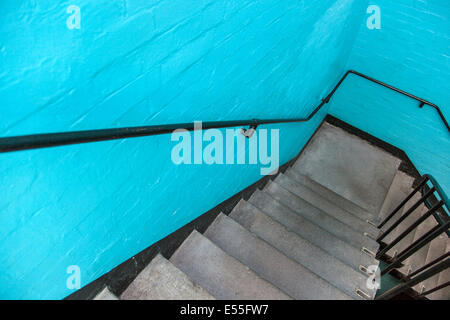 Staircase leading down, blue brick wall in a warehouse Stock Photo