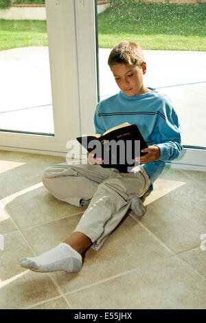 child boy reading Bible on floor 10-11 year years old multicultural multi-cultural Young person people asian  MR © Myrleen Pearson Stock Photo