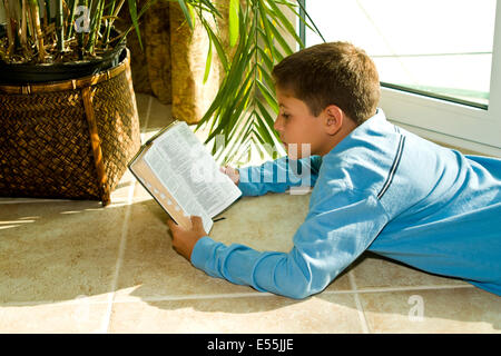 10-11 year years old boy prayerfully reading Bible multi-cultural  Japanese/Caucasian  MR  © Myrleen Pearson Stock Photo