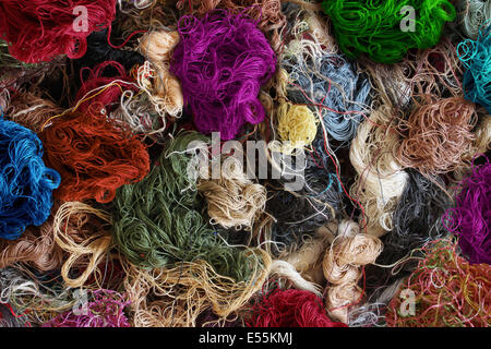 Textile industry background as a group of multi colored entangled sewing threads as a symbol for the fashion industry and clothing business or garment manufacturing as a heap of fibers. Stock Photo