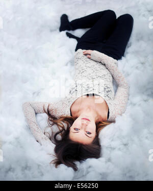 Young woman lying on cotton balls Stock Photo