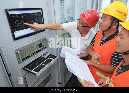 Yiwu, China's Zhejiang Province. 19th July, 2014. Technicians check parameters of the electrification project for Hangzhou-Changsha high-speed railway at Longyou Traction Substation, east China's Zhejiang Province, July 19, 2014. The 933-kilometer high-speed railway linking Hangzhou City and Changsha City is designed at a top speed of 350km/h. The electrification project of the railway has been completed so far. © Tan Jin/Xinhua/Alamy Live News Stock Photo