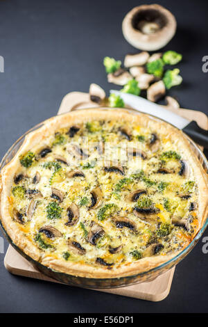 Delicious mushroom quiche on black background with knife Stock Photo