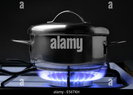 Crock on the gas stove over black background Stock Photo