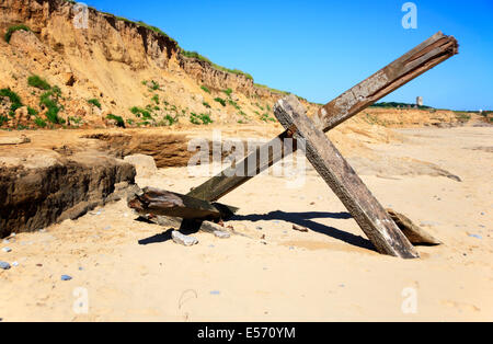 Remains of an old breakwater washed up on the beach at Cart Gap, near Happisburgh, Norfolk, England, United Kingdom.