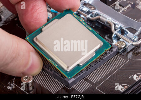 Installation of modern processor in CPU socket on the motherboard Stock Photo