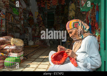 UDAIPUR, INDIA, 3 JANUARY 2014 - Indian hat maker sows a hat in his shop in the streets of Udaipur, India. Stock Photo