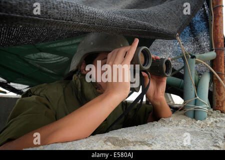 An Israeli soldier from the Field Intelligence Corps scans Beersheba skyline with binoculars to identify locations that were hit by rockets fired from Gaza strip. The Field Intelligence Corps, is responsible for collecting visual information on the battlefield and rapidly transferring it to other forces. Stock Photo