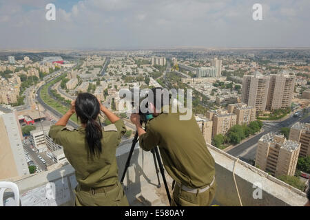 Israeli soldiers from the Field Intelligence Corps scan the skyline of the city of Beersheba with binoculars to identify locations that were hit by rockets fired from Gaza strip. The Field Intelligence Corps, is responsible for collecting visual information on the battlefield and rapidly transferring it to other forces. Stock Photo
