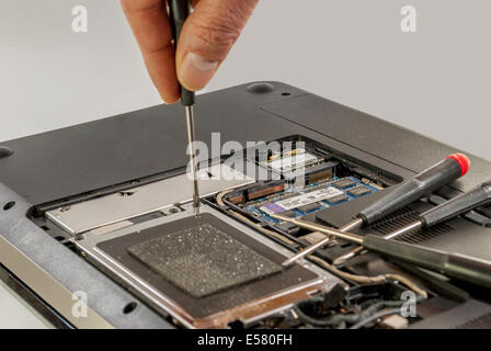 man fixing computer or laptop or notebook with crewdriver Stock Photo