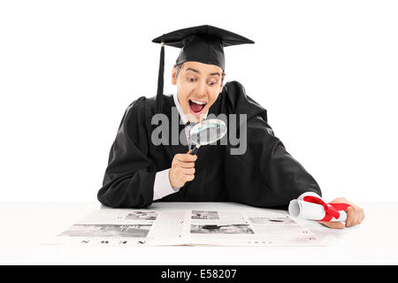 College graduate searching for job in newspaper Stock Photo