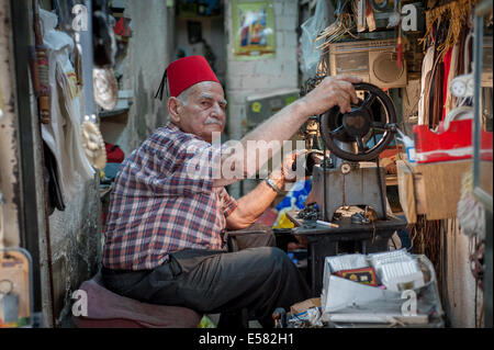 The last working cobbler in his shop at the old market in Nazareth, Israel Stock Photo