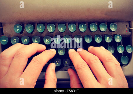 closeup of the hands of a man typing on an old typewriter Stock Photo