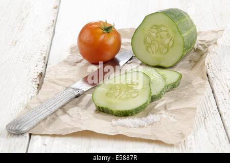 sliced ​​cucumber, salt and a tomato on brown paper Stock Photo