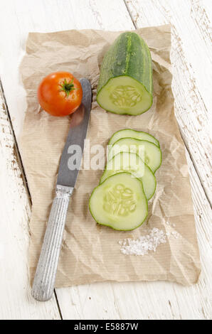 sliced ​​cucumber, salt and a tomato on brown paper Stock Photo