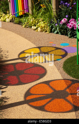 Tatton Park, Manchester, UK. 23rd July, 2014.  Circular Images. and Coloured shadows, coloured circles, spinning wheels, shadows of colour,  red, yellow orange patterns, round, vector, abstract, design, graphic, illustration, light, colours, bright, spectrum, element, art, colorful, icon, colour, color, palette, motion, pattern, blue, creative, fun spectrum on garden pathway at the RHS - Royal Horticultural Society  carnival-themed event at Tatton Park. Stock Photo