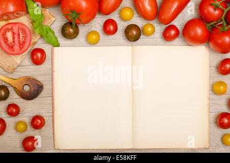 Frame of wet tomatoes with wooden spoon and text space in a recipe book Stock Photo