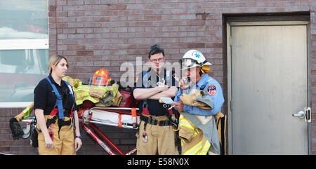 New York City - EMS personnel stand by with stretcher & equipment while firefighters douse flames in Gowanus, Brooklyn Stock Photo