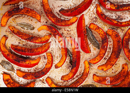 Roasted and spiced pumpkin slices on kitchen tray from above Stock Photo