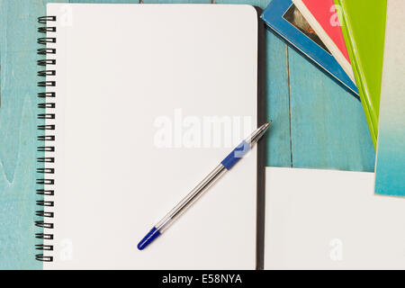 Ring binder, pen and a stack of books. Writing material ready to take notes, do homework or research. Directly above Stock Photo